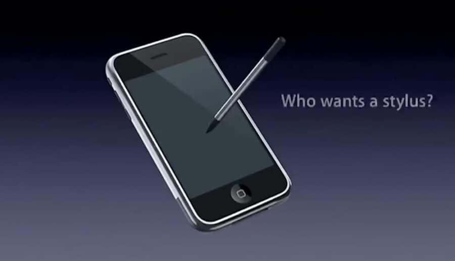 Ein Smartphone und ein Stylus vor dunklem Hintergrund mit dem Text „Who wants a stylus?“.